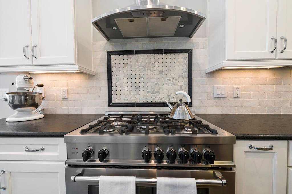 Contemporary kitchen featuring a stainless steel stove and kettle with sleek cabinetry.